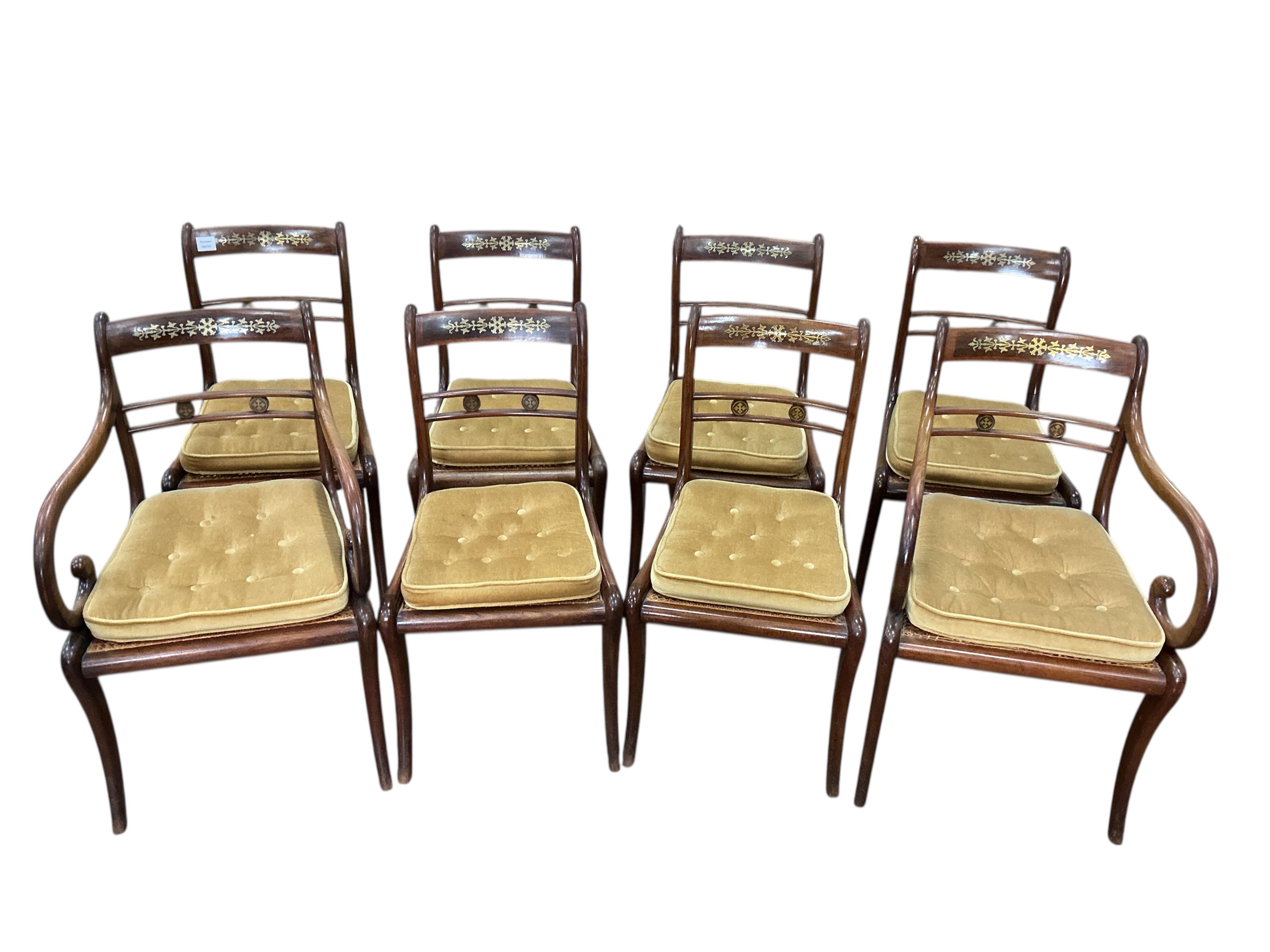 A set of eight Regency cut brass inlaid rosewood cane seat dining chairs, two with arms
